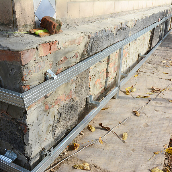 house foundation wall repair, renovation with installing metal sheets on metal frame for waterproofing and protect from wetness.